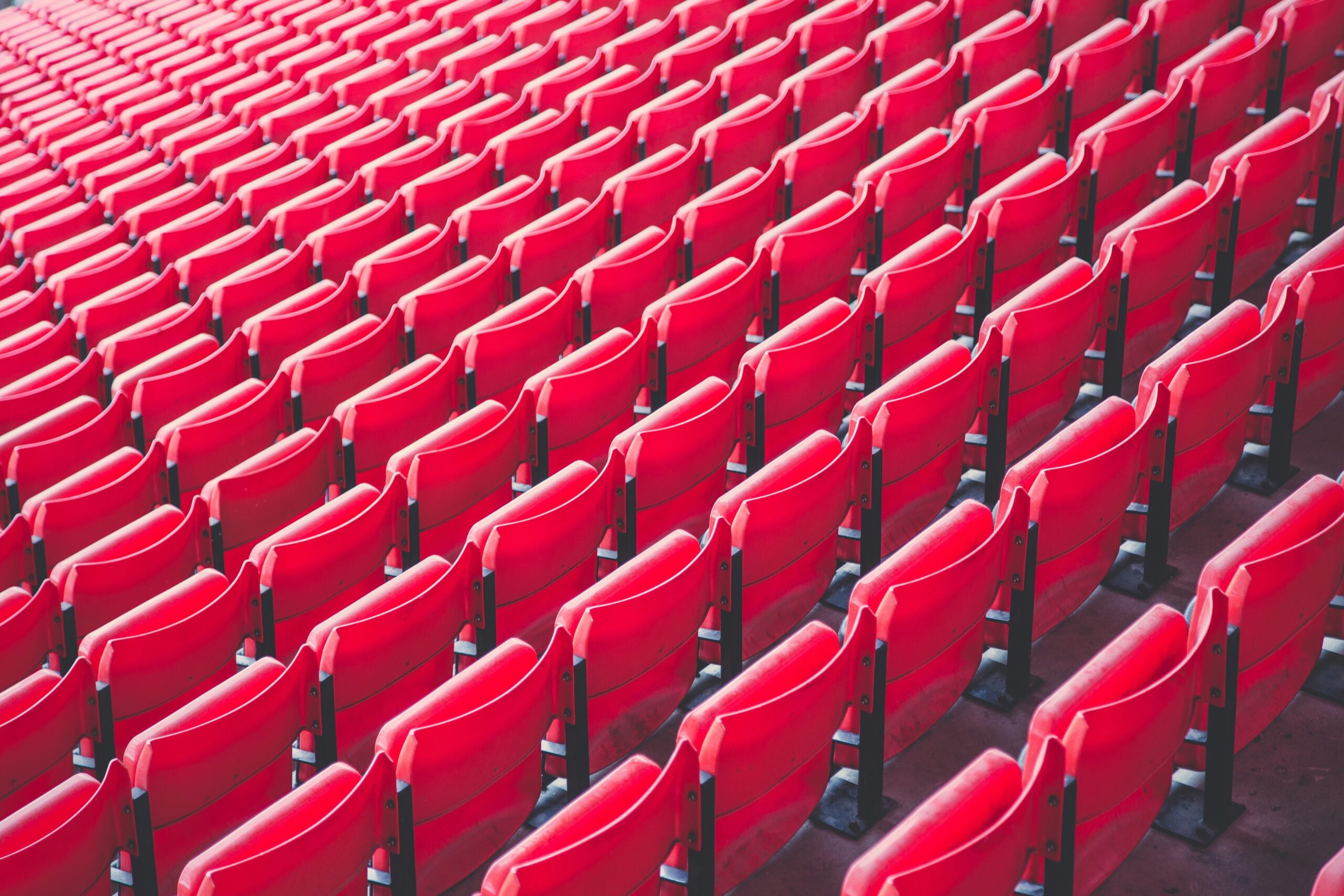Rows of empty seating in a football stadium, calling to mind football, the importance of fans, and Wrexham AFC